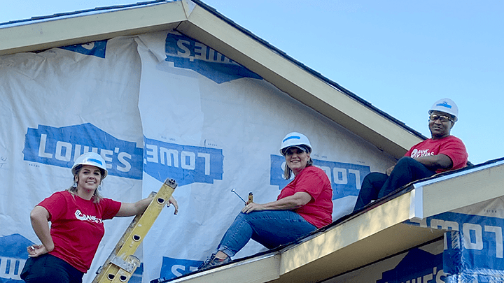Bank of Texas volunteers work on the roof of a Habitat for Humanity home.