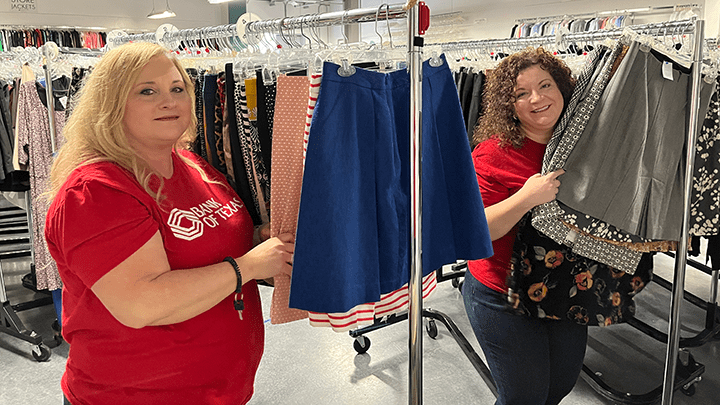 Bank of Texas volunteers helping display clothes at a nonprofit.
