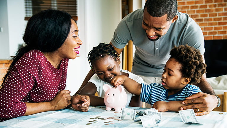 Family breaking open piggy bank to count savings to invest with BOK. 