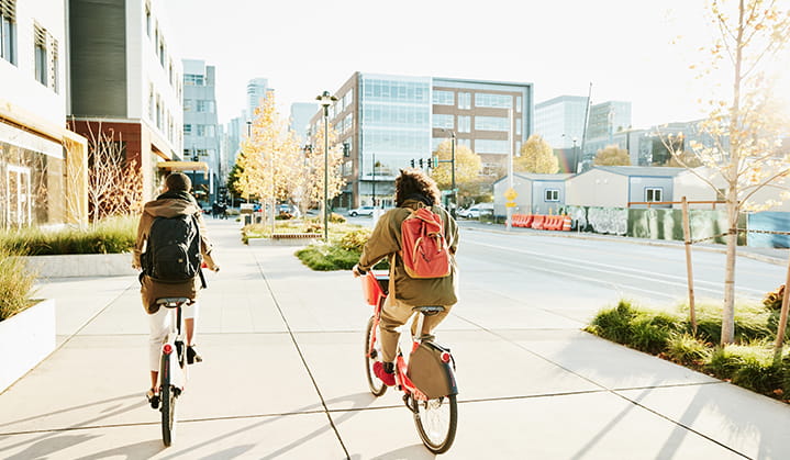 Two individuals riding bicycles, focused on ESG values and investment options.